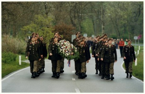 De militairen van de Bravo-compagnie lopen voor een stoet van honderden mensen uit op weg naar de Erebegraafplaats in de duinen. NL-HlmNHA 54037350