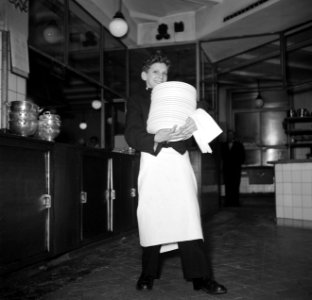 De kleinste en jongste ober met een stapel borden in de keuken van restaurant Wi, Bestanddeelnr 252-9186