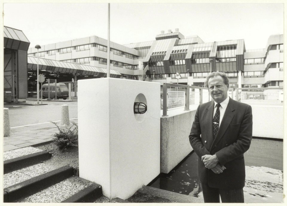 De laatste districts-postdirecteur Hellinga poseert bij het gebouw van de E.K.P. ( P.T.T. Expeditie Knooppunt), NL-HlmNHA 54023557