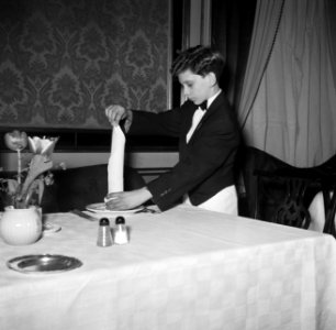 De kleinste en jongste ober dekt een tafel in restaurant Wivex, Bestanddeelnr 252-9192