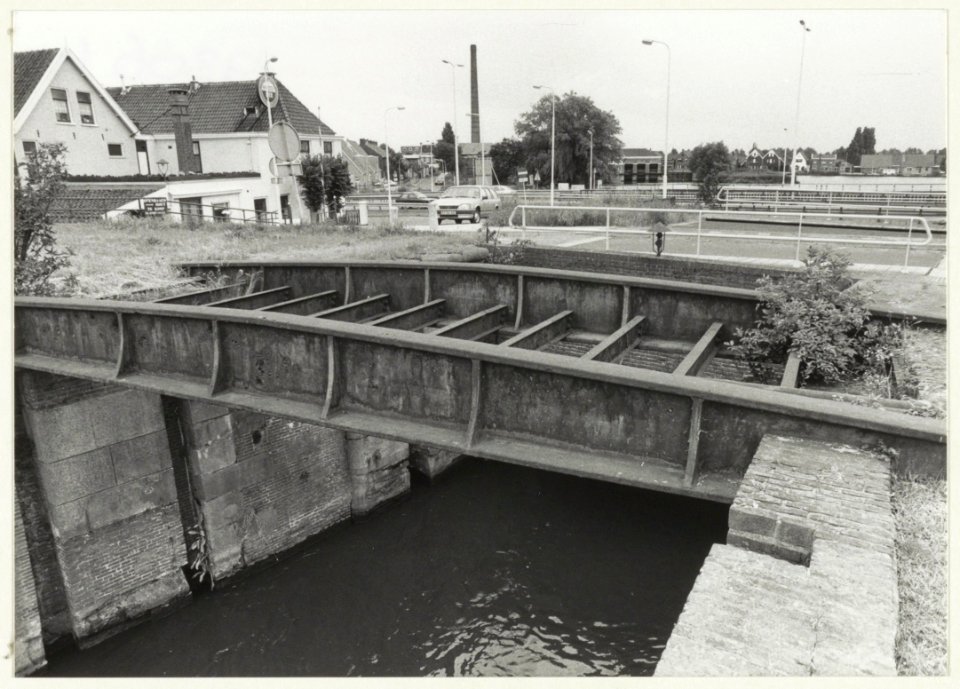 De eeuwenoude Oostsluis met daaroverheen de ijzeren spoorbrug, tevens het laatste restant van de eerste Nederlandse spoorweg. NL-HlmNHA 54023612
