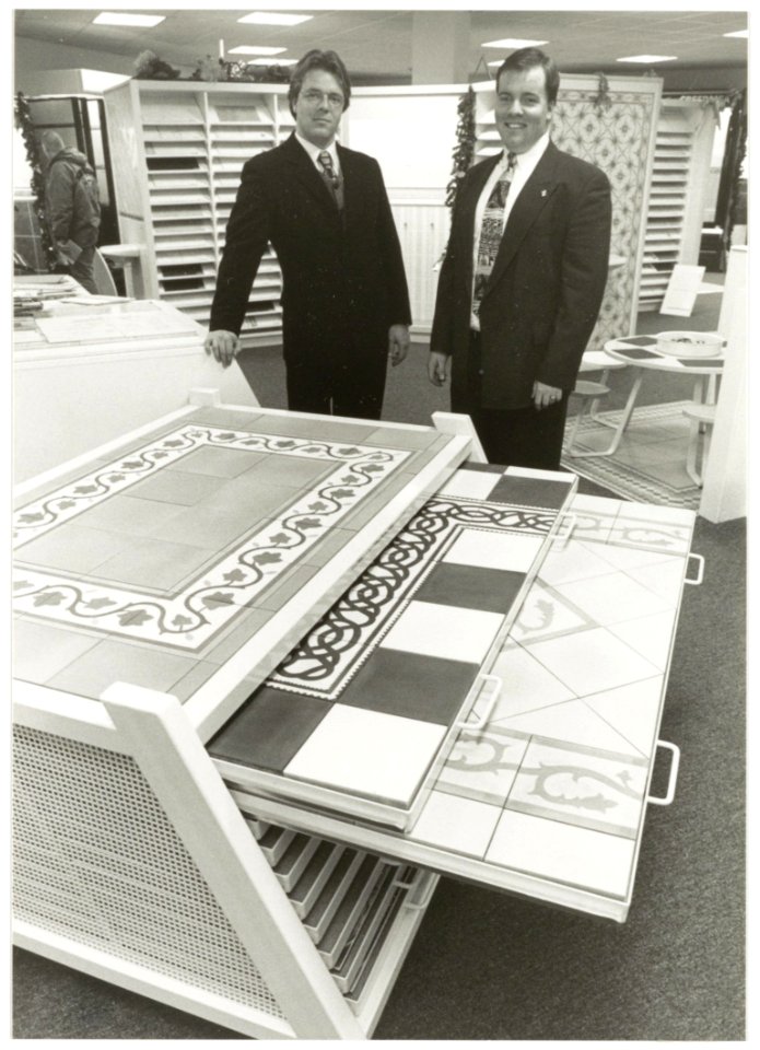 De broers Kol, Dick (l) en Jan jr. in de showroom van Kol's Tegelhandel aan de Stephensonstraat 31, tijdens het 65-jarig bestaan. NL-HlmNHA 54036496