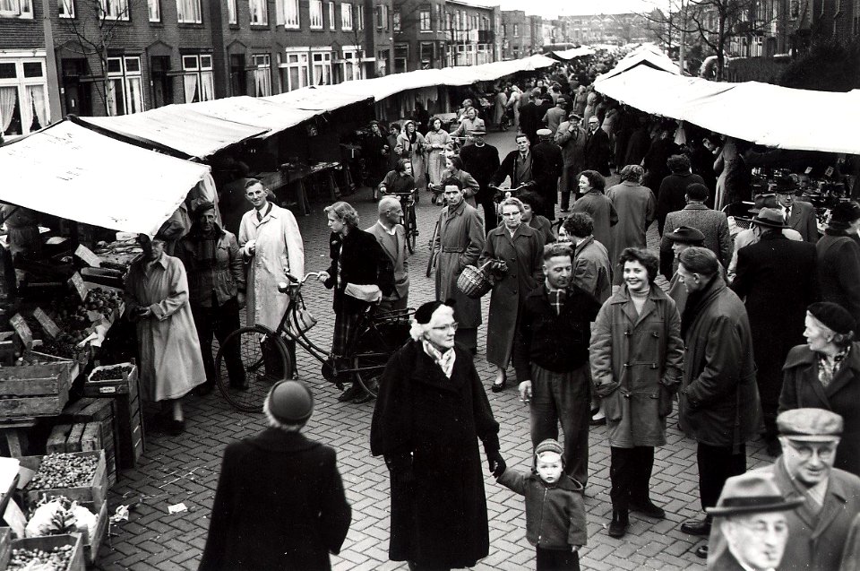 De donderdagse weekmarkt in de Floresstraat, ziende naar het westen. Aangekocht van fotograaf C. de Boer. Identificatienummer 54-008503
