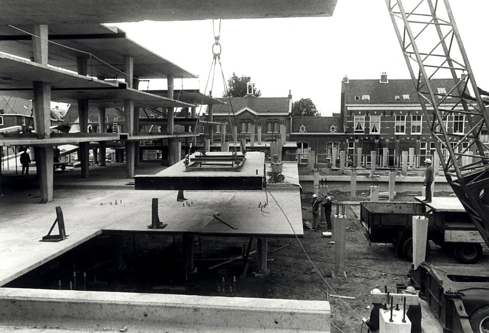 De bouw van de Raaks Parkeergarage in een wat meer gevorderd stadium. Op de achtergrond de gevels aan de Zuiderstraat. Geschonken in 1976 door Dhr. D. Tump. Identificatienummer 54-003988, NL-HlmNHA 1478 25900 K 38