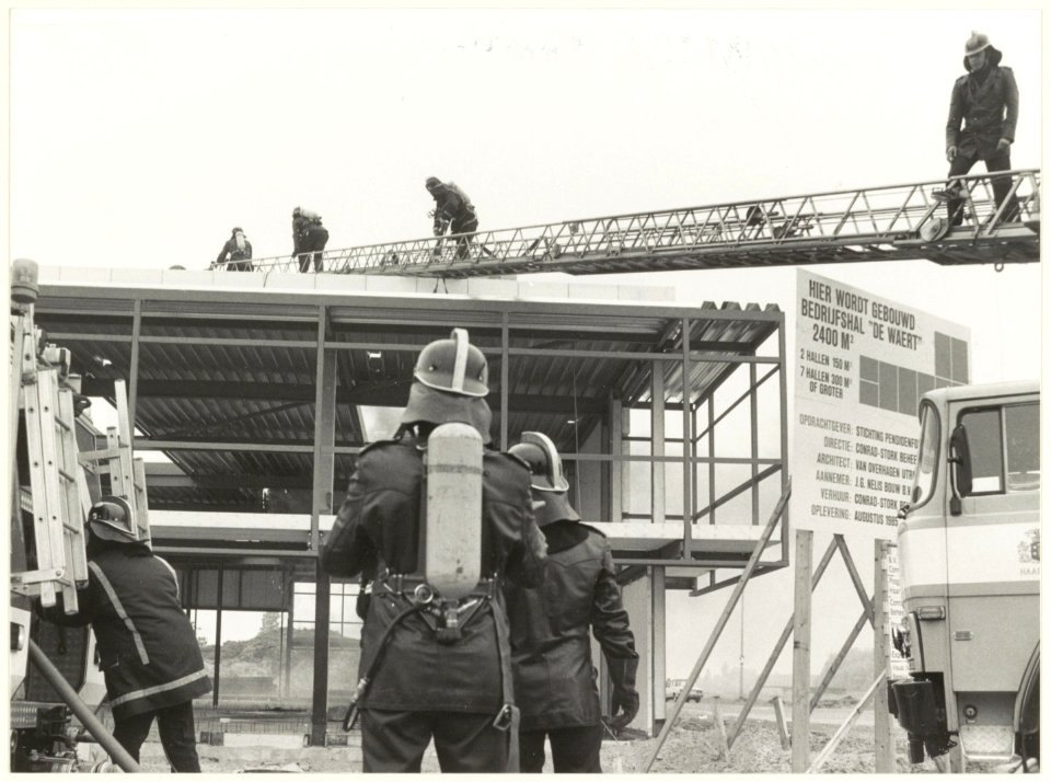 De brandweer aan het werk bij de brand in de bedrijfshal van 'de Waert Services b.v. aan de Drukkersweg, NL-HlmNHA 54025721