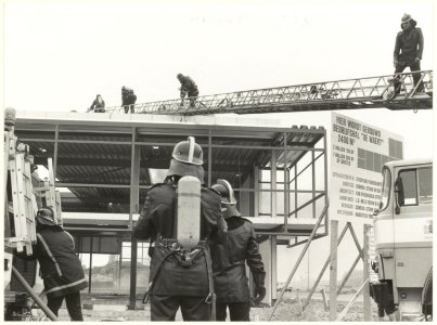 De brandweer aan het werk bij de brand in de bedrijfshal van 'de Waert Services b.v. aan de Drukkersweg, NL-HlmNHA 54025721