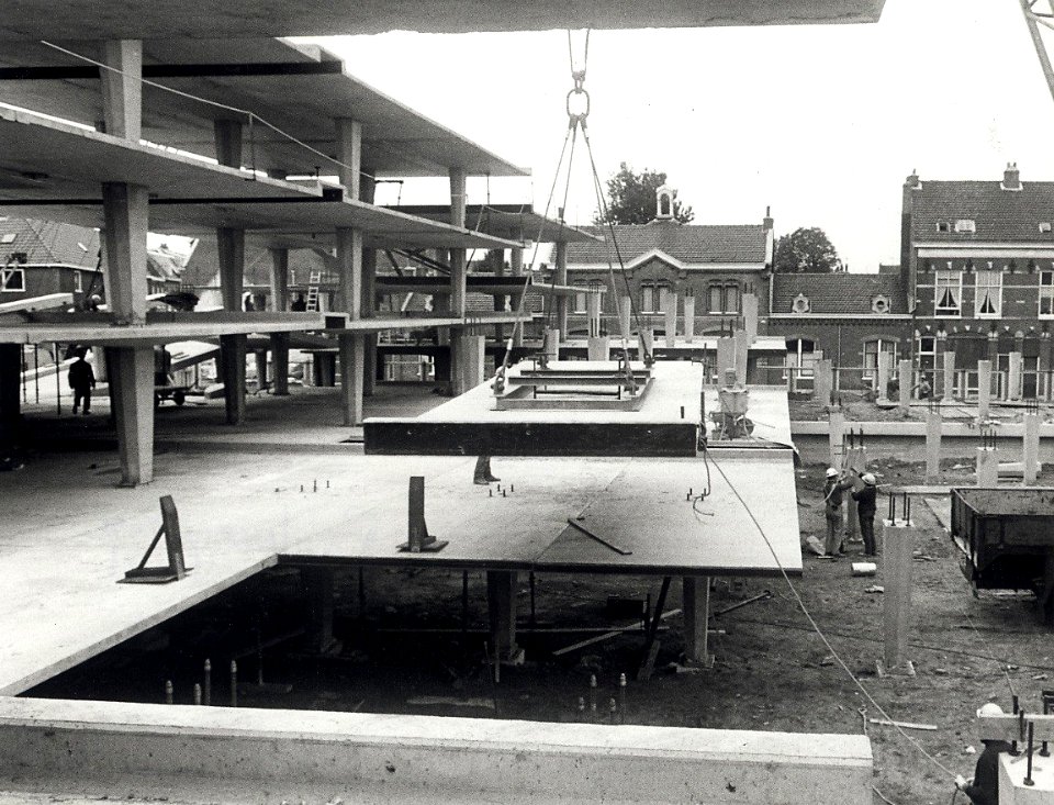 De bouw van de Raaks Parkeergarage in een wat meer gevorderd stadium. Op de achtergrond de gevels aan de Zuiderstraat. Geschonken in 1976 door Dhr. D. Tump. Identificatienummer 54-003989, NL-HlmNHA 1478 25900 K 38