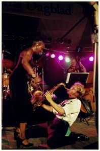 De Amerikaanse zangeres Madeline Bell wuift koelte toe aan de saxofonist Allard Buwalda tijdens een optreden t.g.v. Haarlem Jazz Stad 1997. NL-HlmNHA 54037198