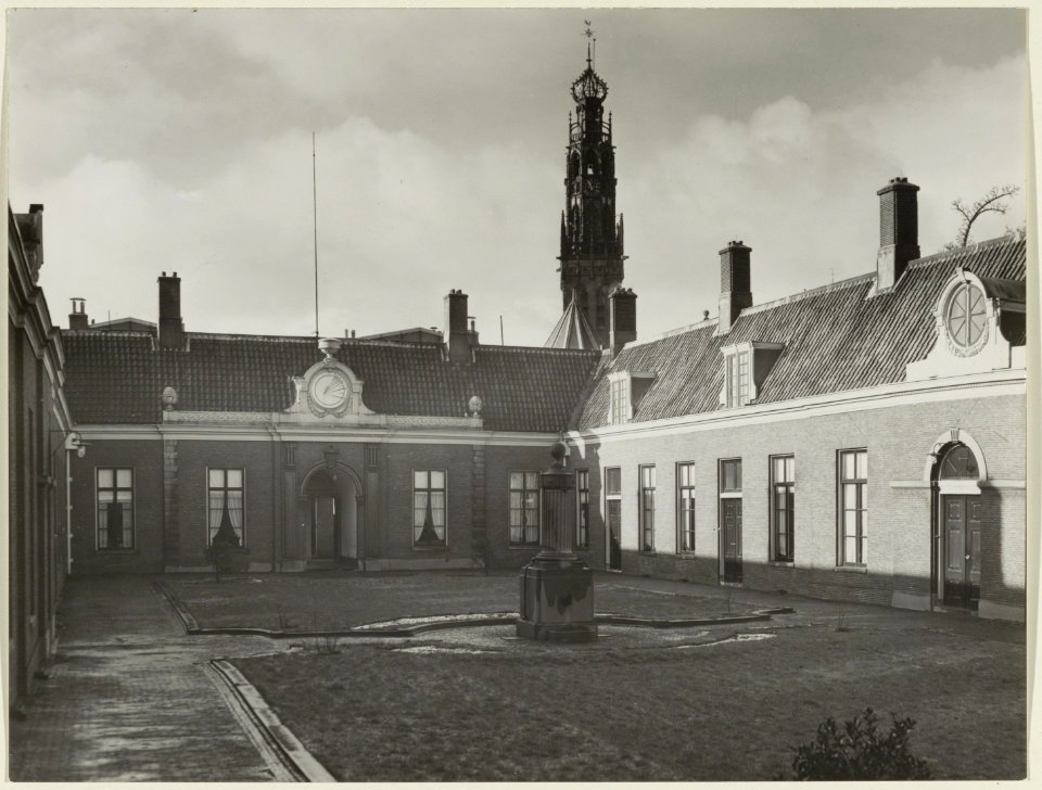 De binnenplaats van het Teylershofje met op de achtergrond de toren van de Bakernesserkerk. NL-HlmNHA 54004688
