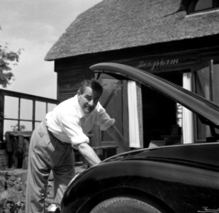 De dirigent Eduard van Beinum kijkt onder de motorkap van zijn open DKW bij zijn, Bestanddeelnr 254-2578