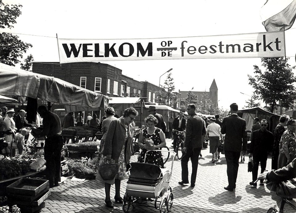 De donderdagse weekmarkt in de Floresstraat, nabij de Timorstraat, ziende naar het oosten. Op de achtergrond de Bethelkerk. Aangekocht in 1977 van fotograaf C. de Boer. Identificatienummer 5, NL-HlmNHA 54010660