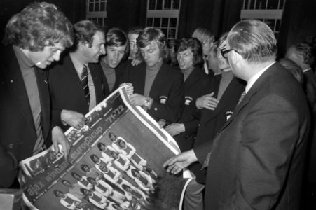De Ajax-spelers rond een poster van het team, Bestanddeelnr 925-6417
