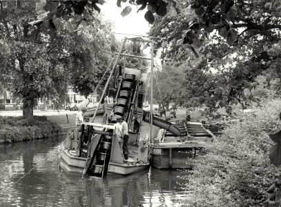 De Baggermolen van de Reinigingsdienst aan het werk in de Kinderhuissingel, ziende naar het noorden. Aangekocht in 1982 van fotograaf C. de Boer, NL-HlmNHA 54012289