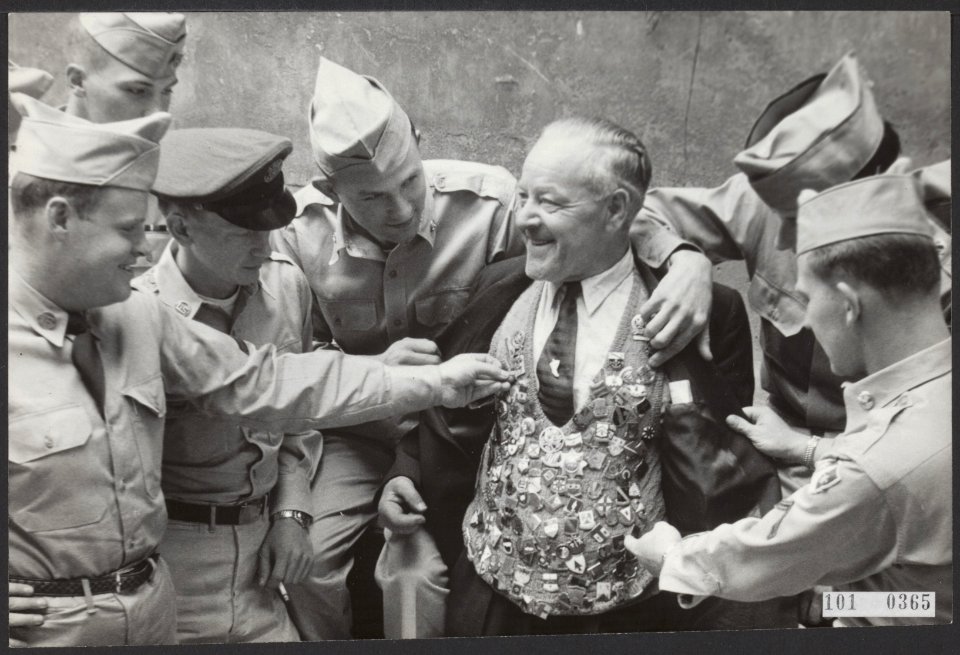 De Amsterdamse gids, de heer Dam, getooid met regimentsinsignes, ontvangen van A, Bestanddeelnr 101-0365