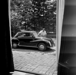 De dirigent Eduard van Beinum wast de voorruit van zijn open DKW bij zijn buiten, Bestanddeelnr 254-2579