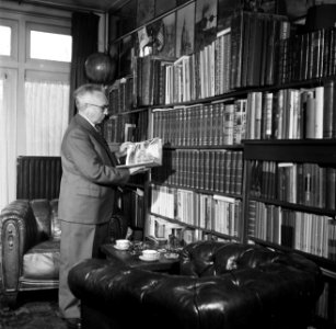 De directeur van luchthaven Schiphol, Jan Dellaert, bij zijn boekenkast in zijn , Bestanddeelnr 254-2464