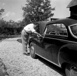 De dirigent Eduard van Beinum kijkt onder de motorkap van zijn open DKW bij zijn, Bestanddeelnr 254-2577