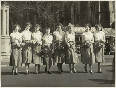 De Haarlemse bloemenmeisjes voor het standbeeld van L.J. Coster en de Grote Kerk. NL-HlmNHA 54010533