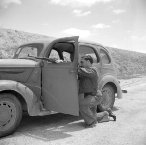 De fotograaf in de Negevwoestijn. Chauffeur richt geknield zijn geweer door het , Bestanddeelnr 255-0772