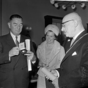 De heer C. Verolme (r.) met in zijn handen de penning en de oorkonde, geflankeer, Bestanddeelnr 918-4407