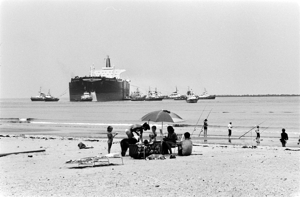De geknakte supertanker Energy Concentration met op de voorgrond mensen in stran, Bestanddeelnr 930-9547