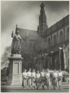 De Haarlemse bloemenmeisjes voor het standbeeld van L.J. Coster en de Grote Kerk. NL-HlmNHA 54010532