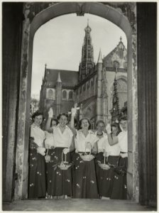 De Haarlemse bloemenmeisjes op de trap van het stadhuis met doorkijk naar de Grote Kerk., NL-HlmNHA 54010530