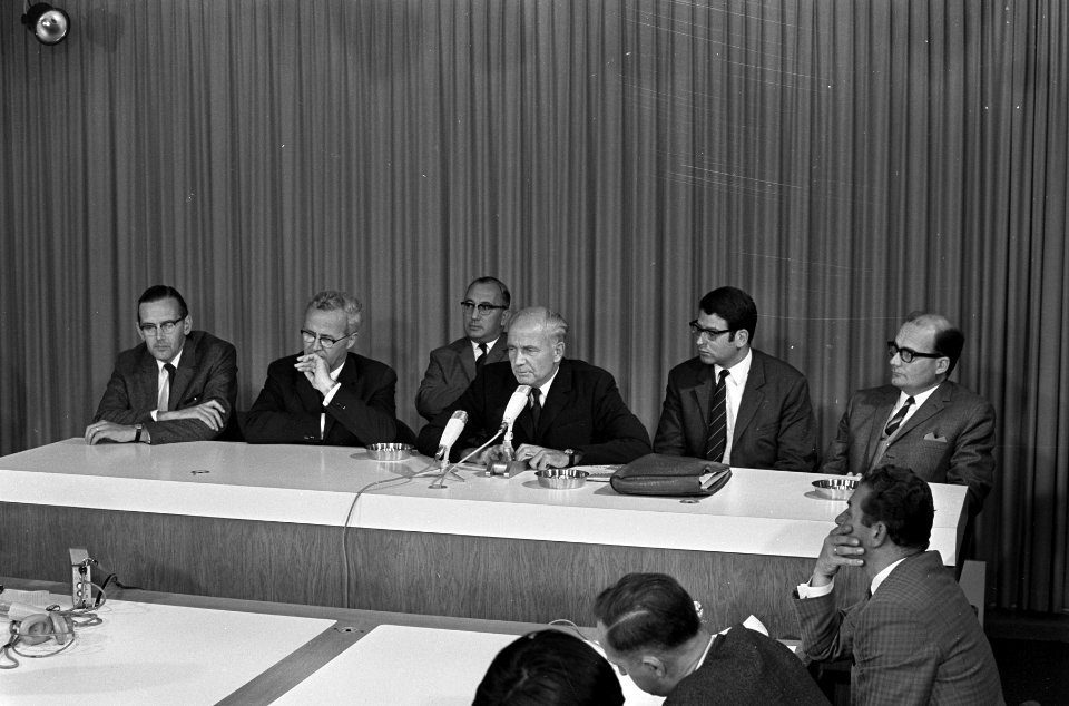 De delegatie houdt op Schiphol een persconferentie. Vlnr. de heren Noteboom, Th…, Bestanddeelnr 921-6689