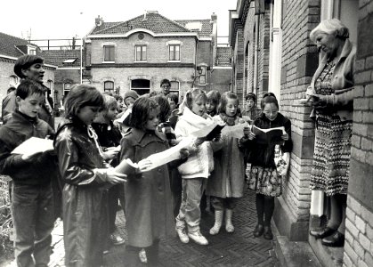 De derde klas van de Dreefschool zingt voor de bejaarde-bewoners van het Zuiderhofje aan de Zuiderstraat. Geschonken in 1989 door United Photos de Boer bv. - Gepubliceerd in het Haarlems Dagblad van 2
