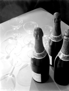 Drie champagneflessen met coupes op een damasten tafelkleed, Bestanddeelnr 252-1133 photo