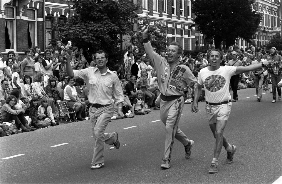 Drie deelnemers komen dansend aan bij de finish, Bestanddeelnr 928-0567