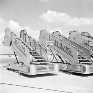 Drie KLM boordtrappen op het afstelgedeelte voor de vliegtuigen op luchthaven Sc, Bestanddeelnr 255-8937