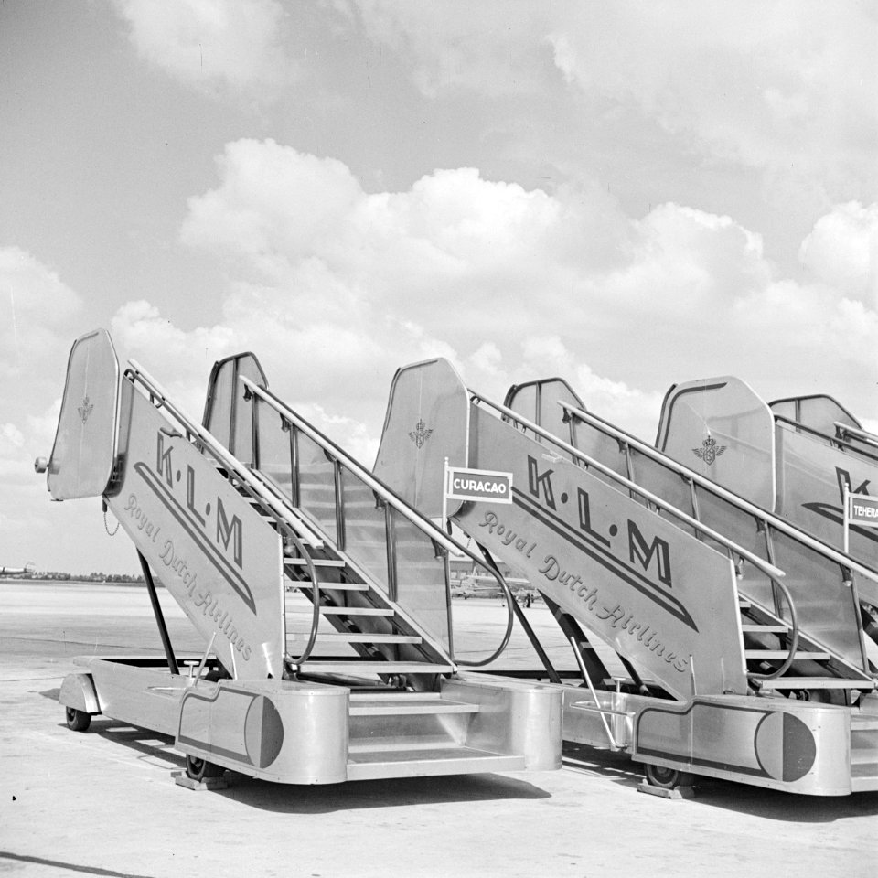 Drie KLM boordtrappen op het afstelgedeelte voor de vliegtuigen op luchthaven Sc, Bestanddeelnr 255-8936