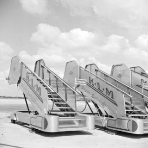 Drie KLM boordtrappen op het afstelgedeelte voor de vliegtuigen op luchthaven Sc, Bestanddeelnr 255-8936