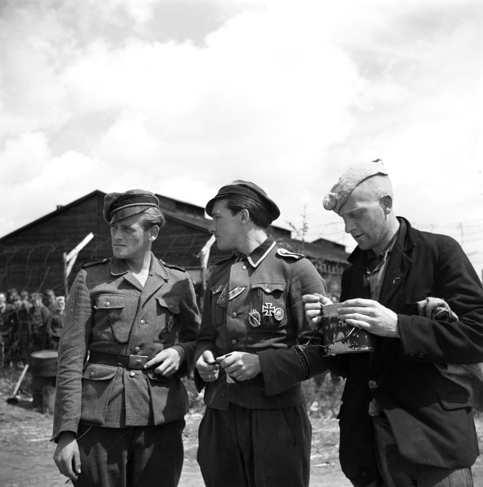 Drie mannen in verschillende uniformen. De middelste draagt het ijzeren kruis, Bestanddeelnr 900-3395