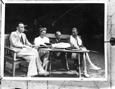 Drie mannen en een vrouw met op de tafel tennisrackets, Bestanddeelnr 902-8243