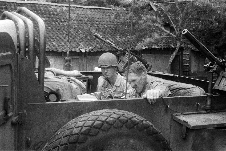 Drie militairen , waarvan twee officieren t zitten in de laadbak van een zwaar…, Bestanddeelnr 275