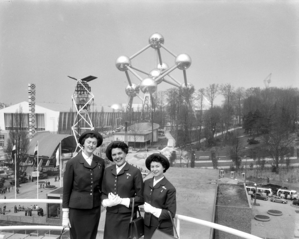 Drie Nederlandse hostesses met geit, op achtergrond Nederlands Paviljoen, Bestanddeelnr 909-4857