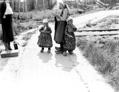 Drie meisjes in Marker kostuurm De oudste is aan het breien, Bestanddeelnr 252-0688