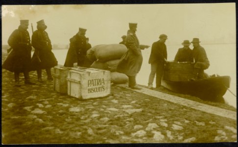 Douaniers aan de waterkant in gesprek met burgers die een boot uitladen, Bestanddeelnr 158-1249