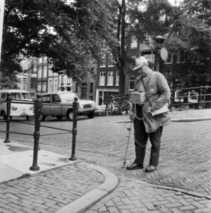 Duitsers boren gaatjes in Amsterdams wegdek, de man met de meter aan het werk, Bestanddeelnr 919-4061