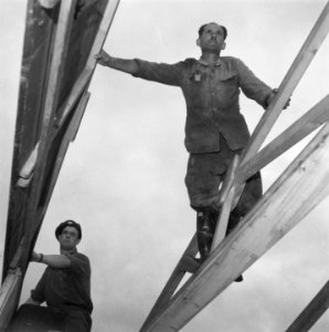 Duitse krijgsgevangene (rechts) en een geallieerde militair bij het opbouwen van, Bestanddeelnr 900-7606