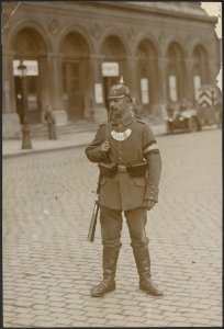 Duitse politieagent op een plein voor een gebouw., Bestanddeelnr 158-2253