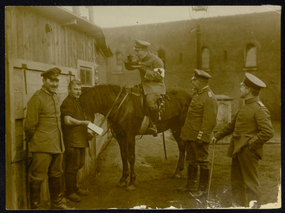 Duitse officier van de medische troepen eet, zittend op een paard, onder toezien, Bestanddeelnr 158-0587