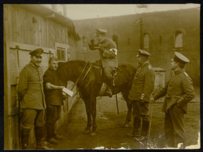 Duitse officier van de medische troepen eet, zittend op een paard, onder toezien, Bestanddeelnr 158-0587