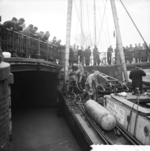 Duiker onderzoekt fundering brug Prinsengracht, grote publieke belangstelling, Bestanddeelnr 911-8905