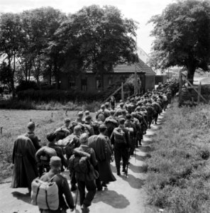 Duitse krijgsgevangen in colonne passeren een boerderij, Bestanddeelnr 900-3307