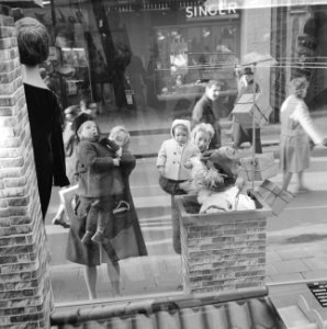 Drukte in de Amsterdamse winkelstraten Etalage met dik dak waar een piet in de , Bestanddeelnr 915-8077