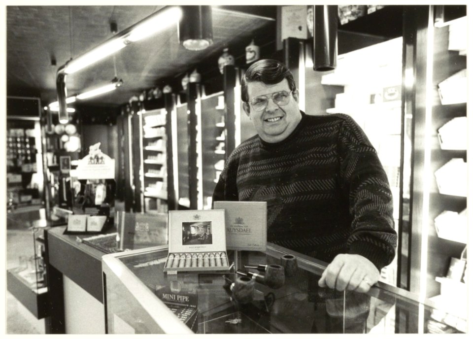 Dik van Eskert in zijn tabakswinkel in de Grote Houtstraat. NL-HlmNHA 54031673