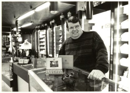 Dik van Eskert in zijn tabakswinkel in de Grote Houtstraat. NL-HlmNHA 54031673
